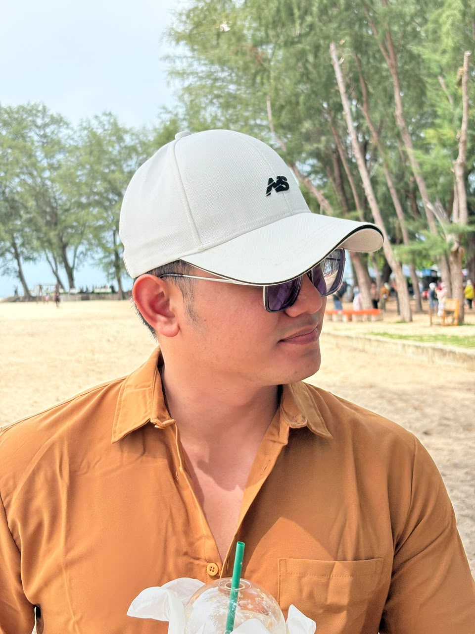 Mizan at the beach in a white cap and sunglasses