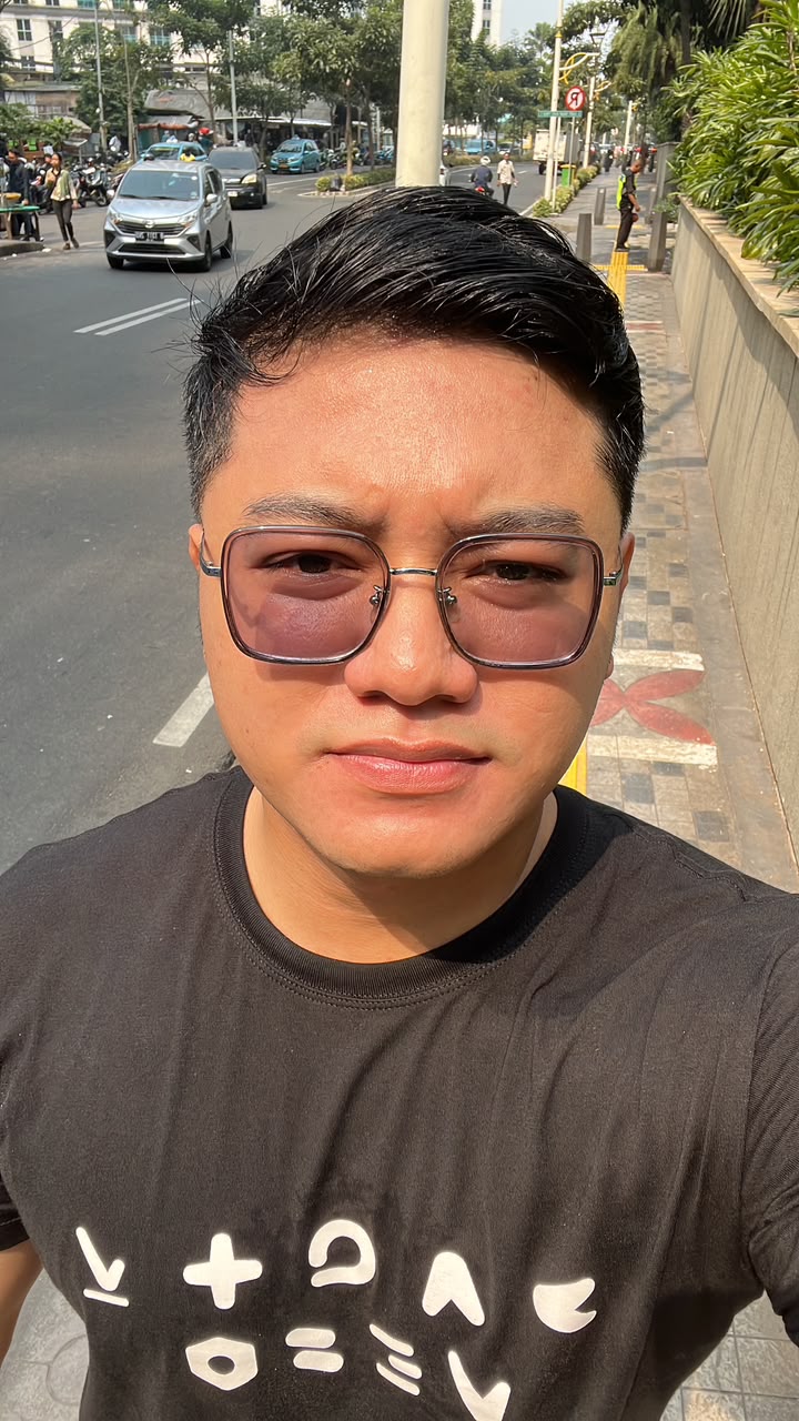 Mizan on a city street wearing tinted glasses